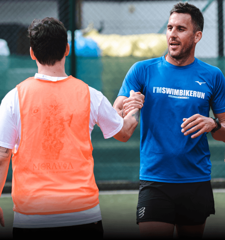 Dvaja členovia tímu podávajúci si ruky po odohratom zápase vo futbale.