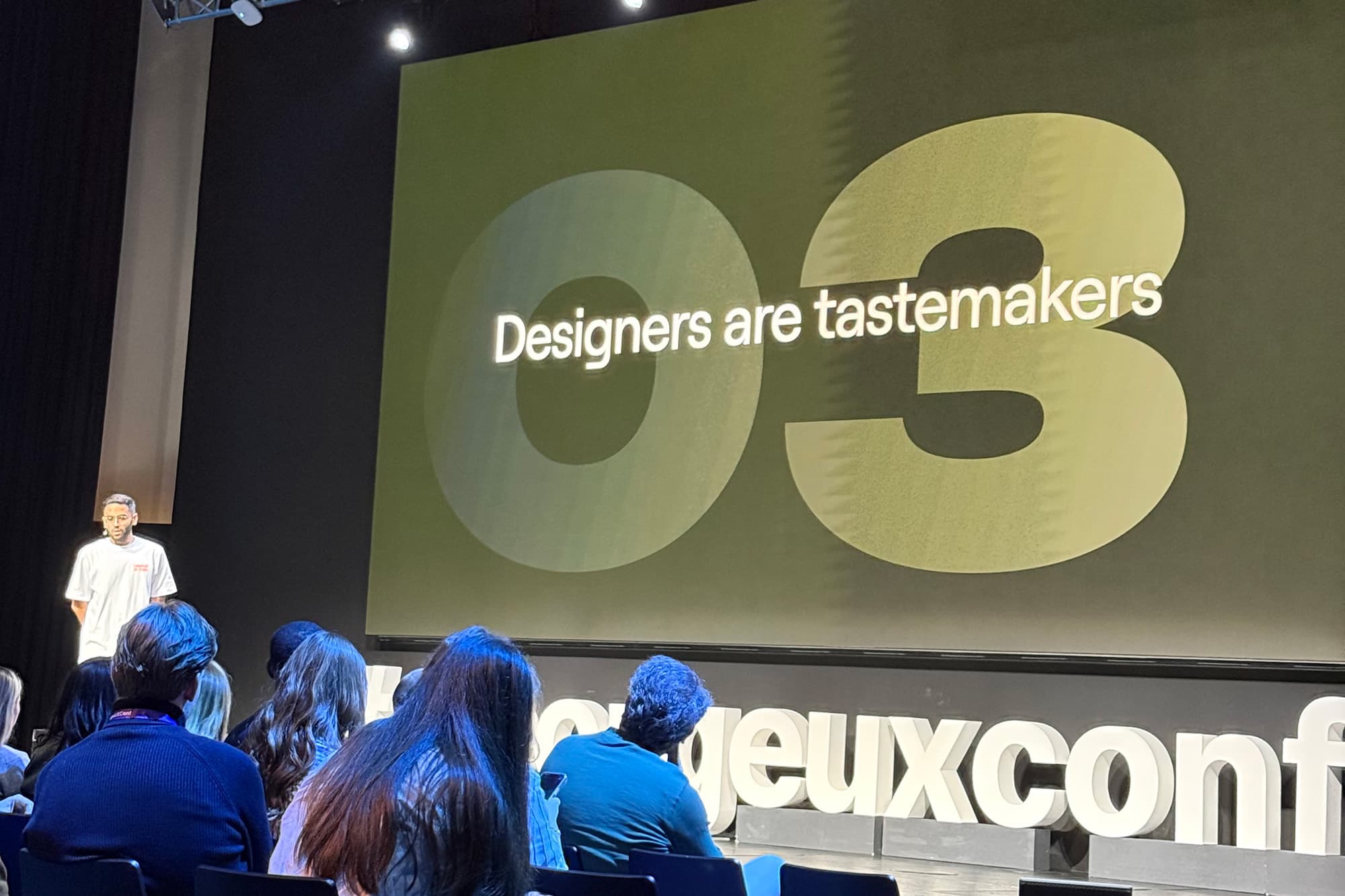 Fotografia z prednášky Miga Reyesa - slajd s nápisom: "Designers are testmakers".